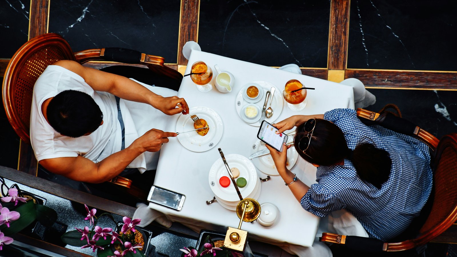A couple sharing a quiet meal, distracted by their phones