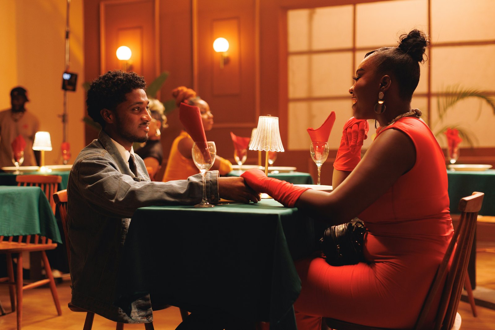 A couple holding hands over candlelight at dinner
