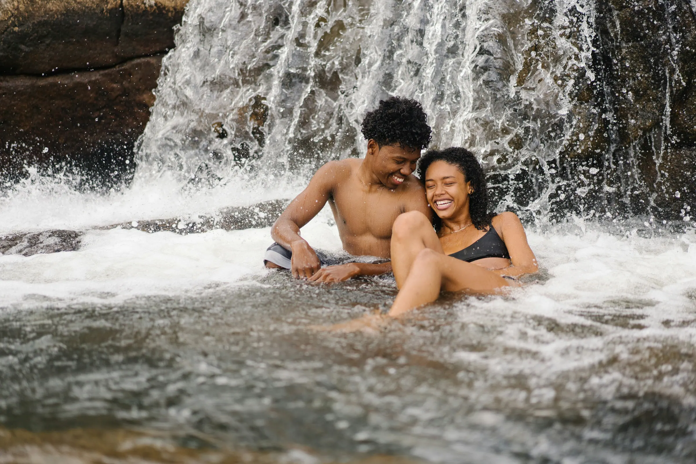 A couple reconnecting at a waterfall on a Tourbirth union journey